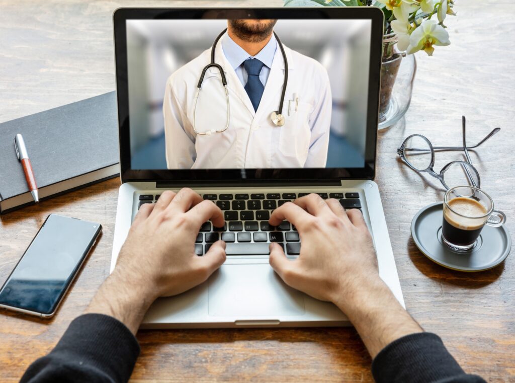 Telemedicine concept. Doctor GP on a computer screen, office desk background