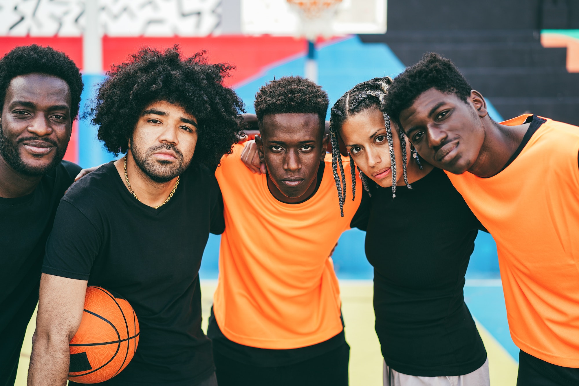 African friends playing basketball outdoor - Focus on center faces