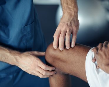 Doctor examining pain leg of patient